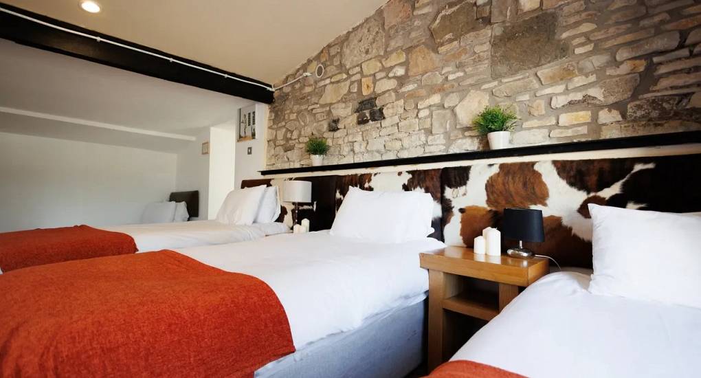 Triple bedroom with cow hide backdrop at Autumn Cottage Bristol