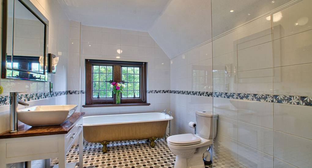 Long tiled bathroom with bath
