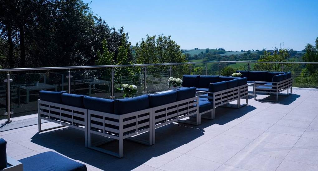 Large Terrace area with loungers with hills and clear blue sky in the background