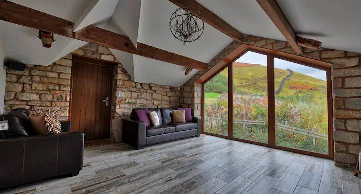 Lounge area with wooden beams and a large feature pointed arch window