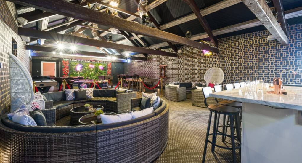 Games Room with bar area and large circular wicker chair and table with games in the background