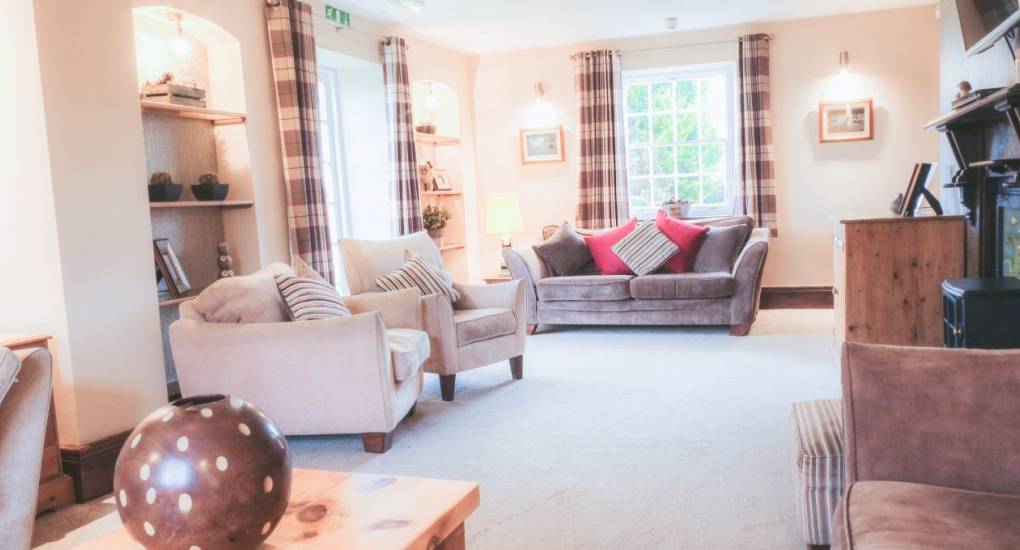 View of the lounge area with furniture and open curtains letting the light in