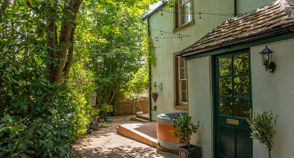 View of the private grounds around the side of the house with hot tub