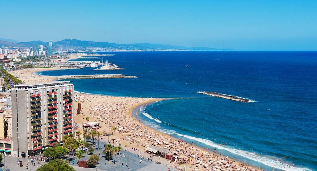 Aerial view of Barceloneta beach and blue Mediterranean coast, perfect setting for a sunny barcelona hen do.