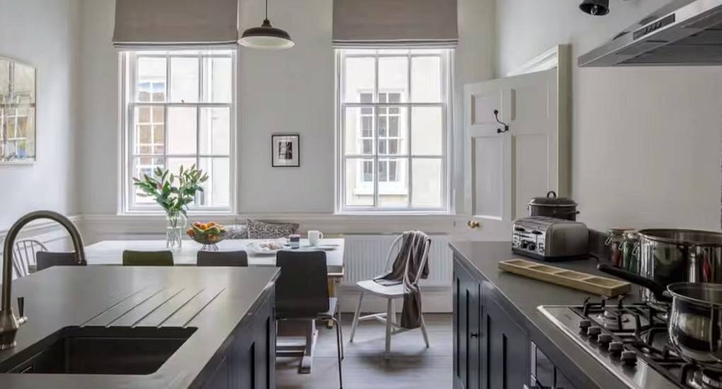 The modern kitchen island and dining space at Heart of the City, a central Bath hen party house for 13 guests.
