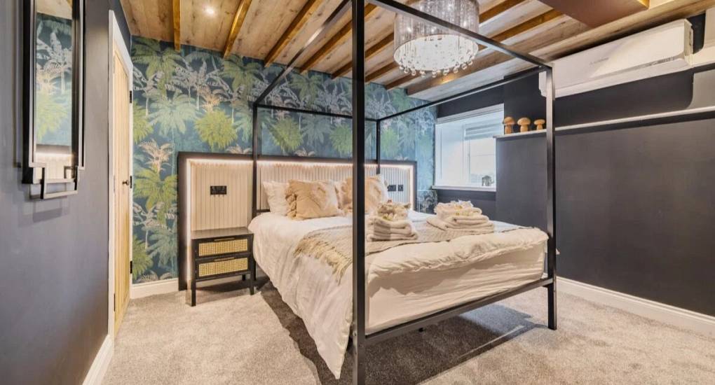 Master bedroom with four post king side bed made up for guest
