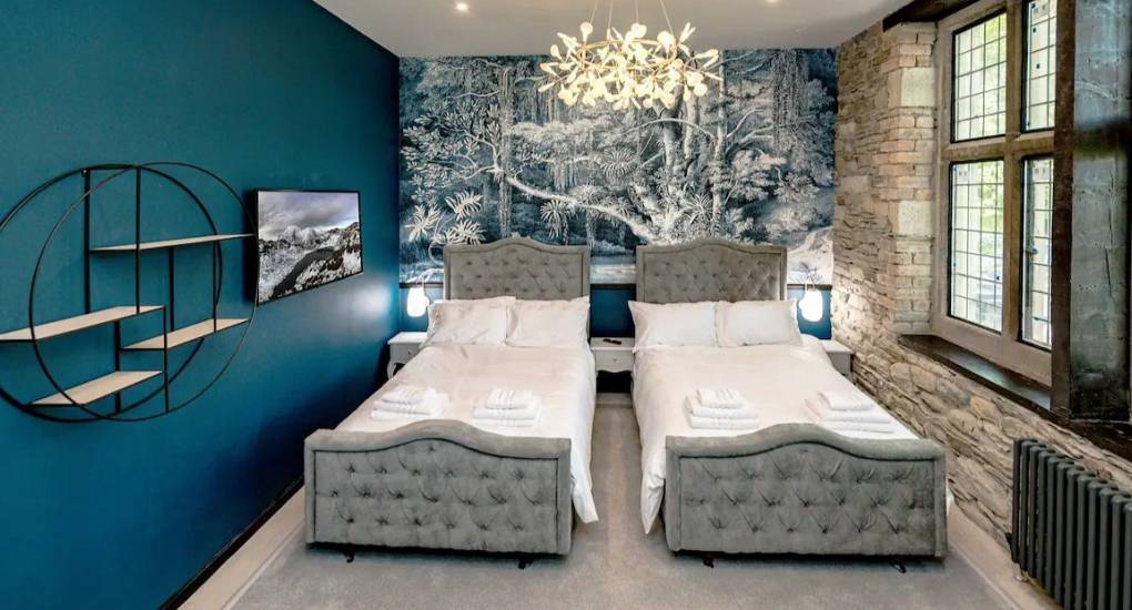 Spacious bedroom showing two stylish made up single beds