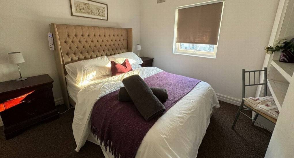 A bedroom at the Cardiff Party House with freshly made double bed