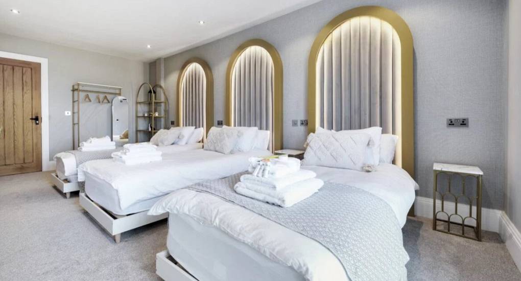 Bedroom with three single beds with tall stylish headboards 