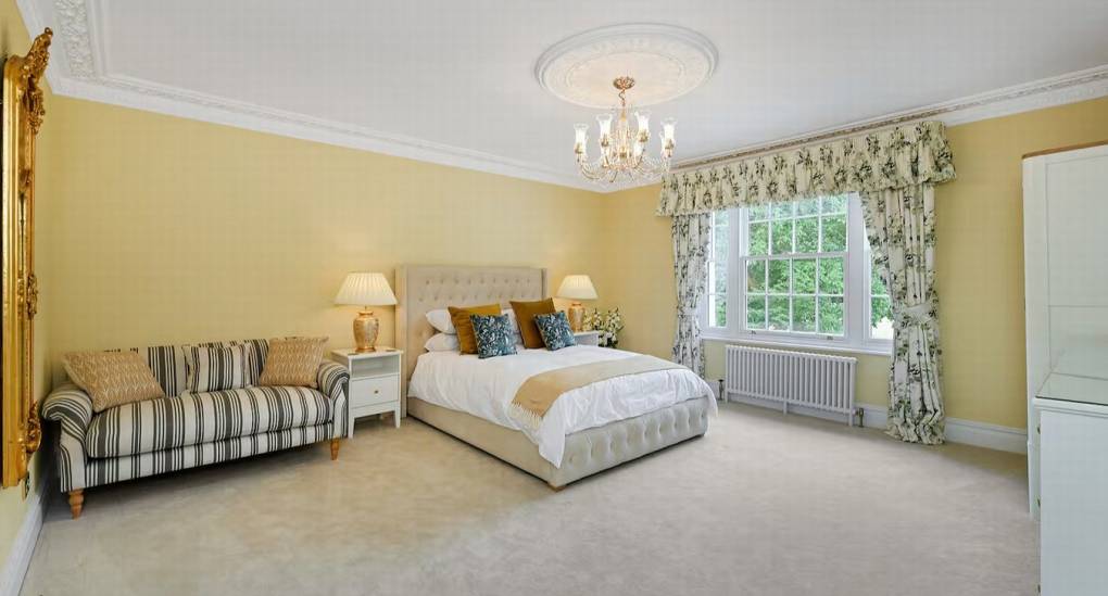 King-sized bed, sofa, and private en-suite in Bedroom 2 at The Parsonage, a luxury Nottingham hen party house.