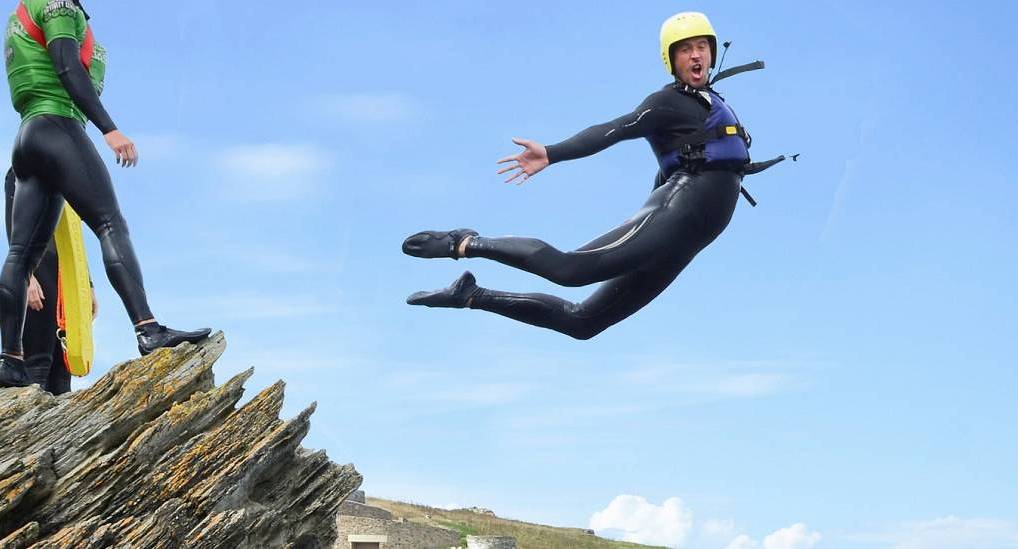 Man jumping and posing whilst Coasteering 