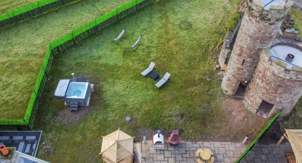 Birds eye view of the gardens showing picnic tables, firepit, BBQ and the watch tower