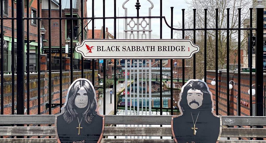 Black Sabbath Bridge sign and heavy metal bench plaques along Birmingham canal, setting the scene for a Birmingham stag do.