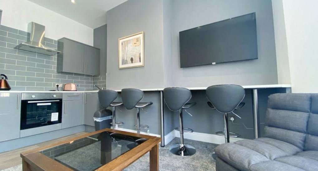 Modern grey kitchen and breakfast bar at Fair View, a spacious Blackpool hen party house near town centre bars.