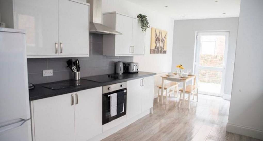 Modern white kitchen and dining area at The Buchs, a popular party-ready central Blackpool hen house.