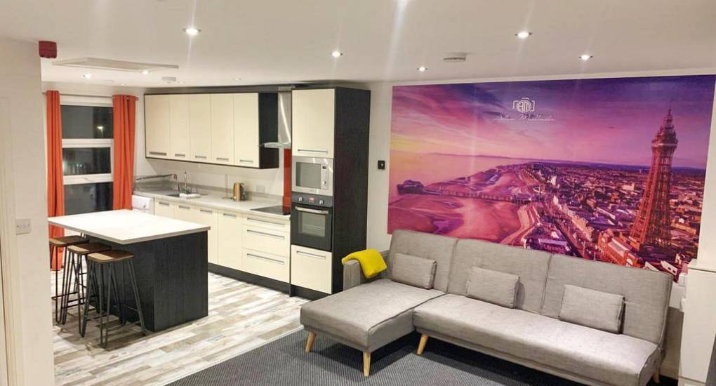 Open-plan living room with Blackpool Tower mural at The Smooch, seaside hen party apartments near North Pier.
