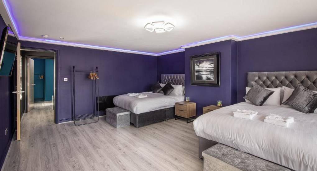Stylish purple bedroom with LED ceiling lighting at The Views, a modern town centre Blackpool hen apartment.