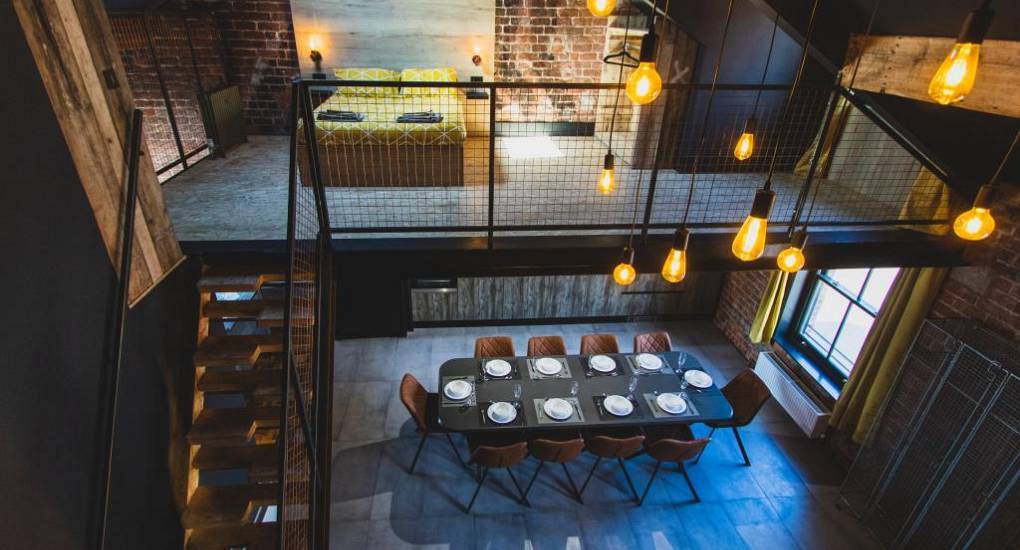 Industrial mezzanine loft and group dining area at Upper Floor, a luxury central Blackpool hen apartment.
