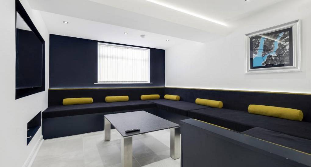 Wraparound navy cinema lounge seating at Wellie Boots, a spacious group Blackpool hen party accommodation.