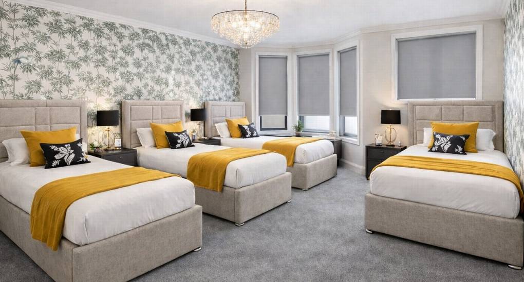 One of the bright spacious bedrooms at the hen party house, the Bournemouth Hot Tub Garden. Four made up single beds.