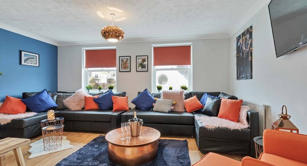 Spacious living room with corner leather seating and copper table at Bright Lights, Kemptown hen house near beach.