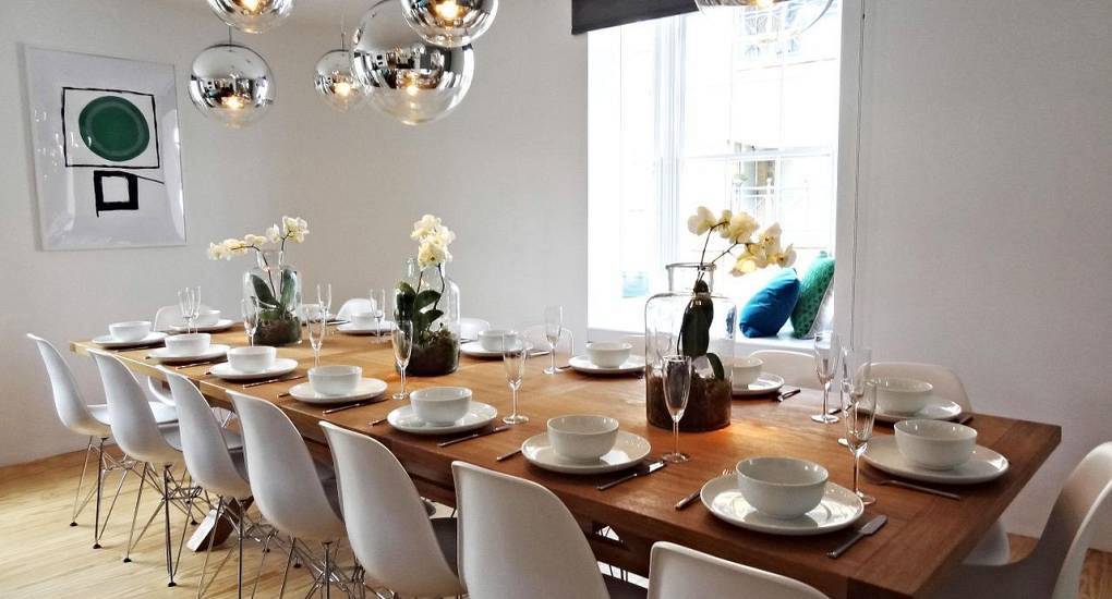 Grand timber dining table set for group pre-drinks at Celebrate House, spacious 3-floor Brighton hen accommodation.