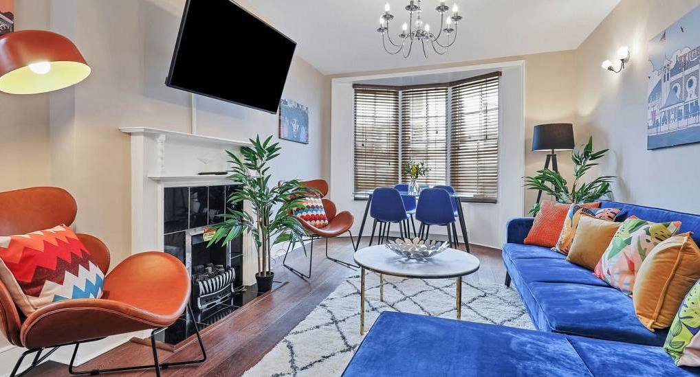 Royal blue plush corner sofa and bay window seating at Central Pad, city centre Brighton hen party apartment.