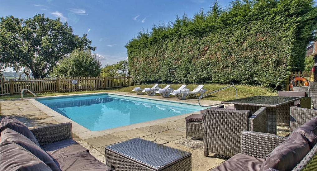 Private outdoor swimming pool and sun loungers at Oasis Estate, a luxury Sussex rural hen party house for 29.