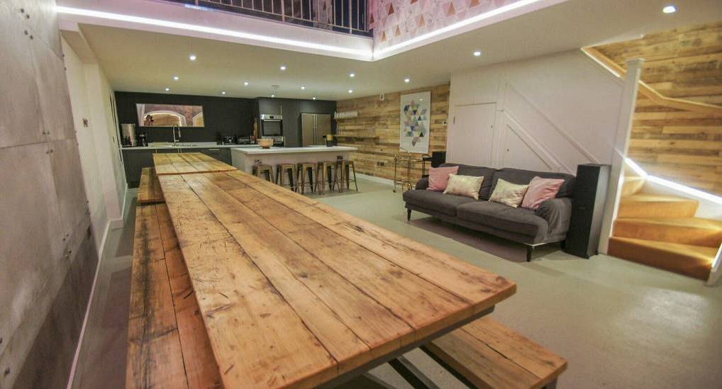 Massive rustic wooden bench table and open plan living space at The Arches, large Brighton hen townhouse for 20.