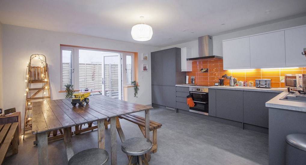 The modern open plan kitchen and wooden dining table at 3 Alpha & Beta, central Bristol hen party apartments for 22.
