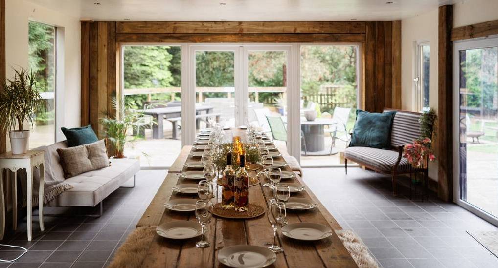 The long wooden banquet dining table and garden views at BB Party Pad, a large Bristol hen party house for 25.