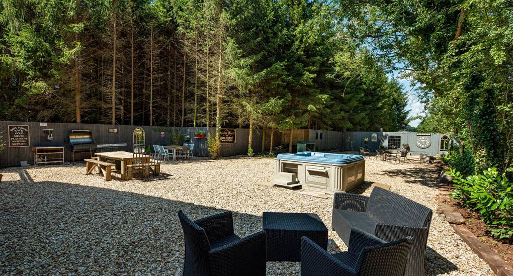 Long garden with firepit and hot tub in view