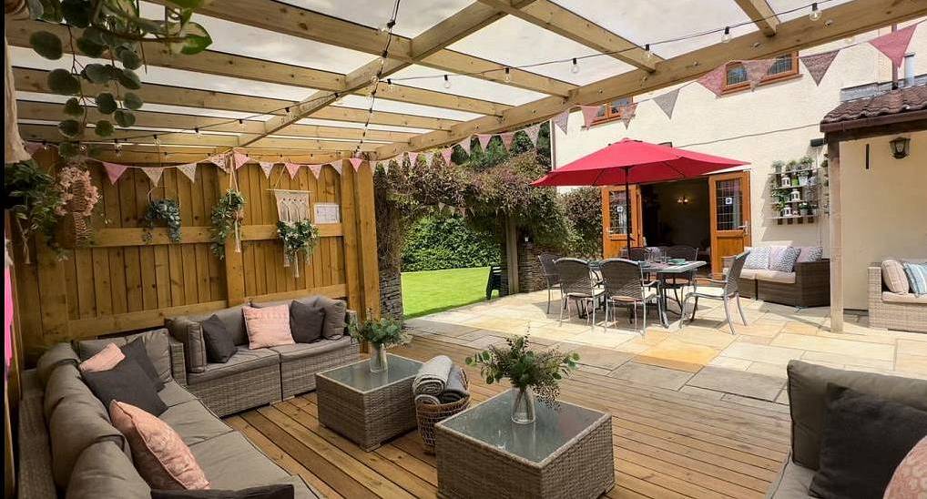 The covered wooden pergola patio deck with lounge sofas at Bristol Hill, a Bristol hen party house with garden.