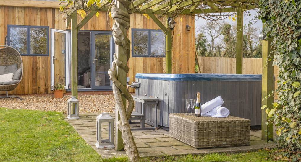 The timber vine pergola and sunken hot tub deck at The Vines, a secluded hen party house near Bristol and Bath.