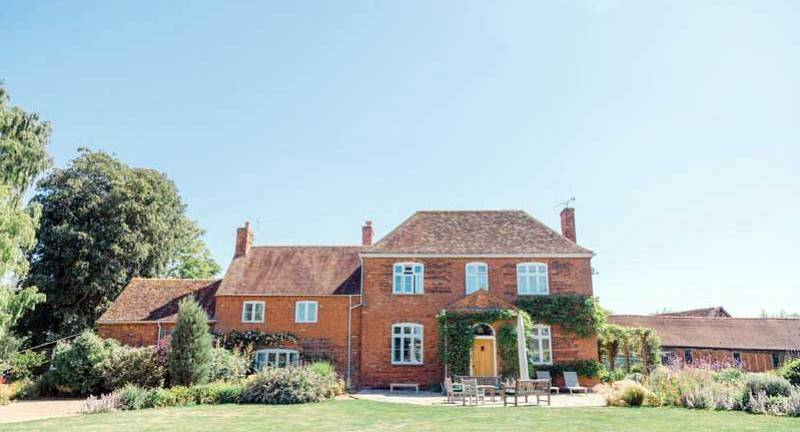 Historic red brick country house exterior and manicured grounds at The Ranch near Cambridge.
