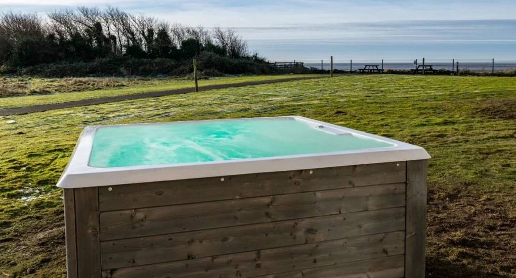 Hot tub in the garden with the Irish sea at the bottom of the garden