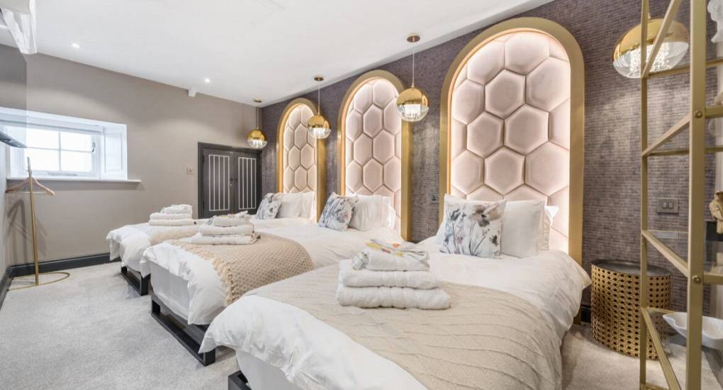 Bedroom with three beds with impressive ornate headboards 