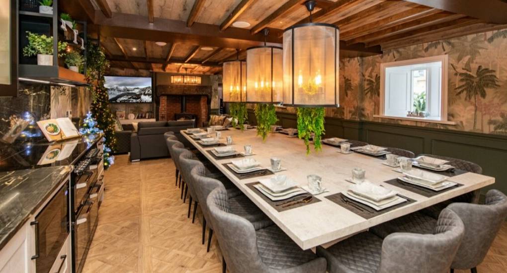 Large kitchen dining area with large kitchen table and the lounge and open fire in the background