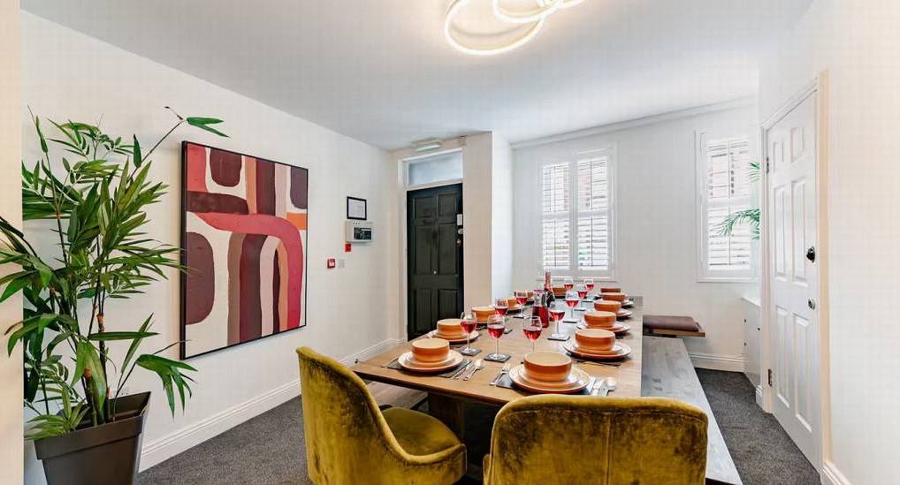 Contemporary dining room with wooden table and mustard velvet chairs at Chester 15, central Chester hen house.