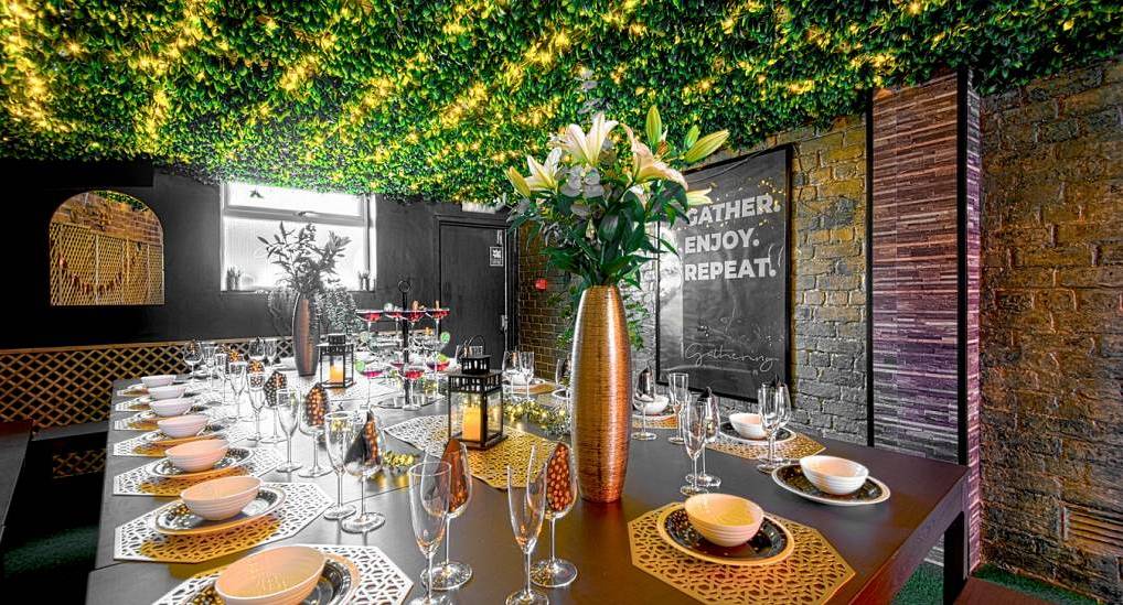 Grand dining room with foliage ceiling, fairy lights and gold table settings at The Big House in Chester.