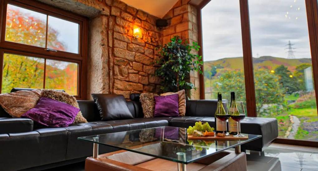Looking out the feature window over the coffee table with bottle of wine and fruit