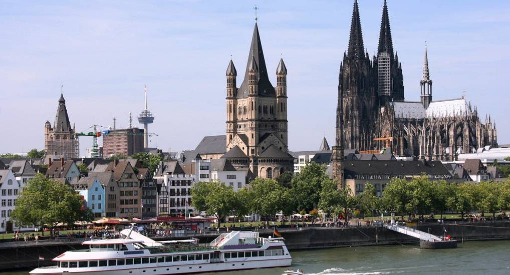 Cologne Cathedral spires and Great St Martin Church skyline over Rhine River, iconic setting for a Cologne stag do.
