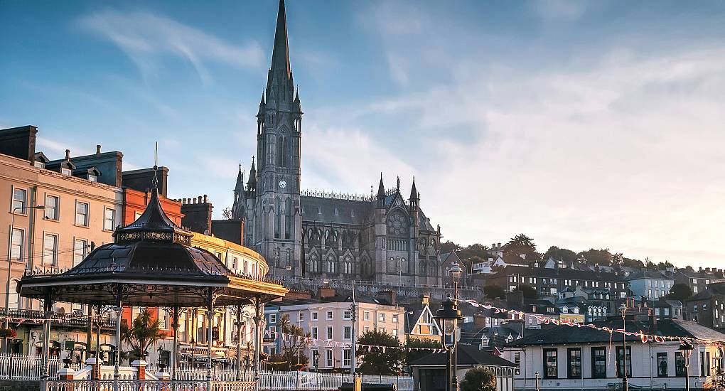St Colman's Cathedral and Victorian bandstand illuminated in warm sunset light, scenic backdrop for a Cork hen do.