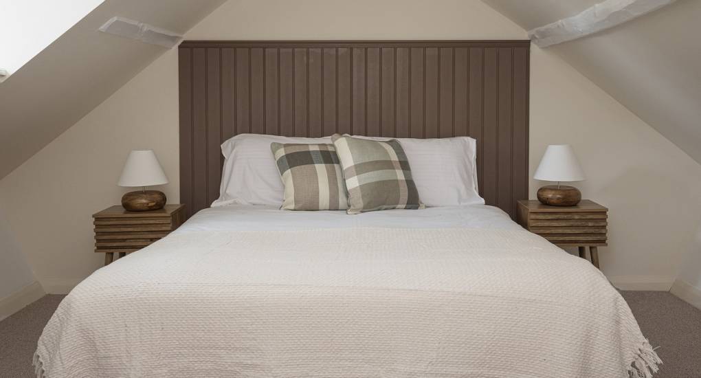 Master bedroom with feature headboard on large double bed