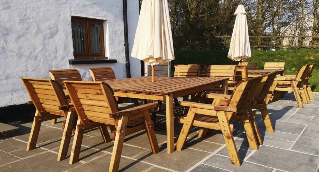 patio area with large outside wooden table and chairs with umbrella