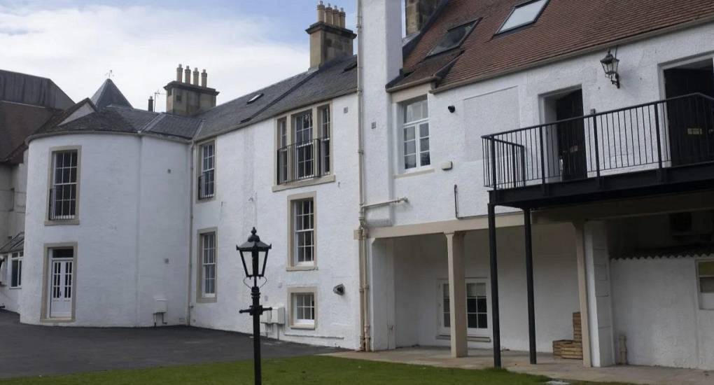 White historic stone exterior with balconies and courtyard at Lux Life, central Edinburgh hen party apartments.