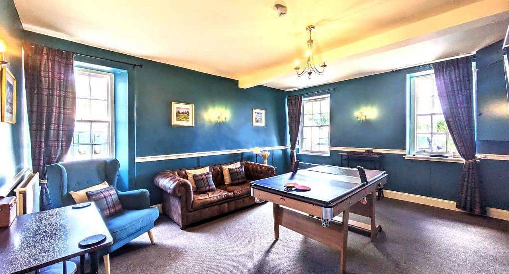 Teal games room with table tennis table and leather chesterfield sofa at Primrose Cottage near Edinburgh.