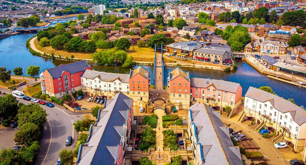 Aerial view of Exeter Quay footbridge and waterfront buildings on River Exe, scenic setting for an Exeter stag do.