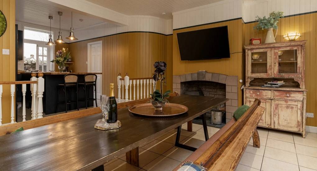 The heart of Highland House: A long rustic dining table and bench seating in the kitchen diner, perfect for group meals and hen party activities.