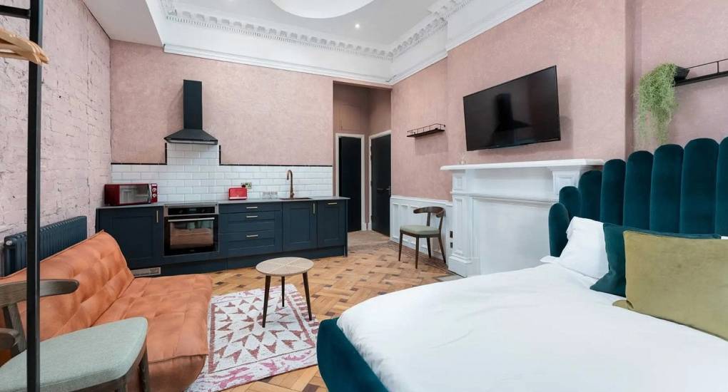 Modern white kitchen at Extravagance Edinburgh with a coffee machine and essential amenities, ideal for self-catering Edinburgh hen apartments in the Leith area.